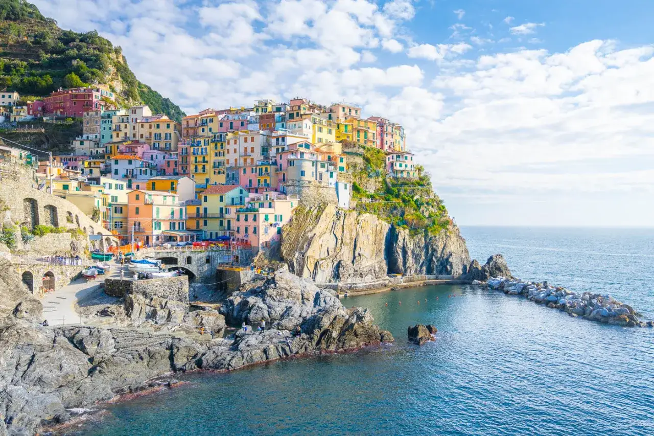 Bunte H&auml;user kleben an steilen Felsen &uuml;ber dem Meer. Ein perfekter Ort f&uuml;r **La Spezia Wandern** und unvergessliche Ausblicke.