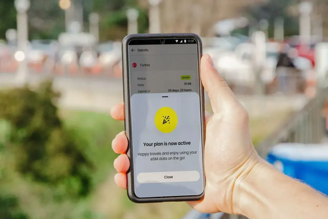 Dłoń trzyma telefon z aktywnym planem eSIM Revolut na Turcję. Ciesz się podróżą z danymi na wyciągnięcie ręki.