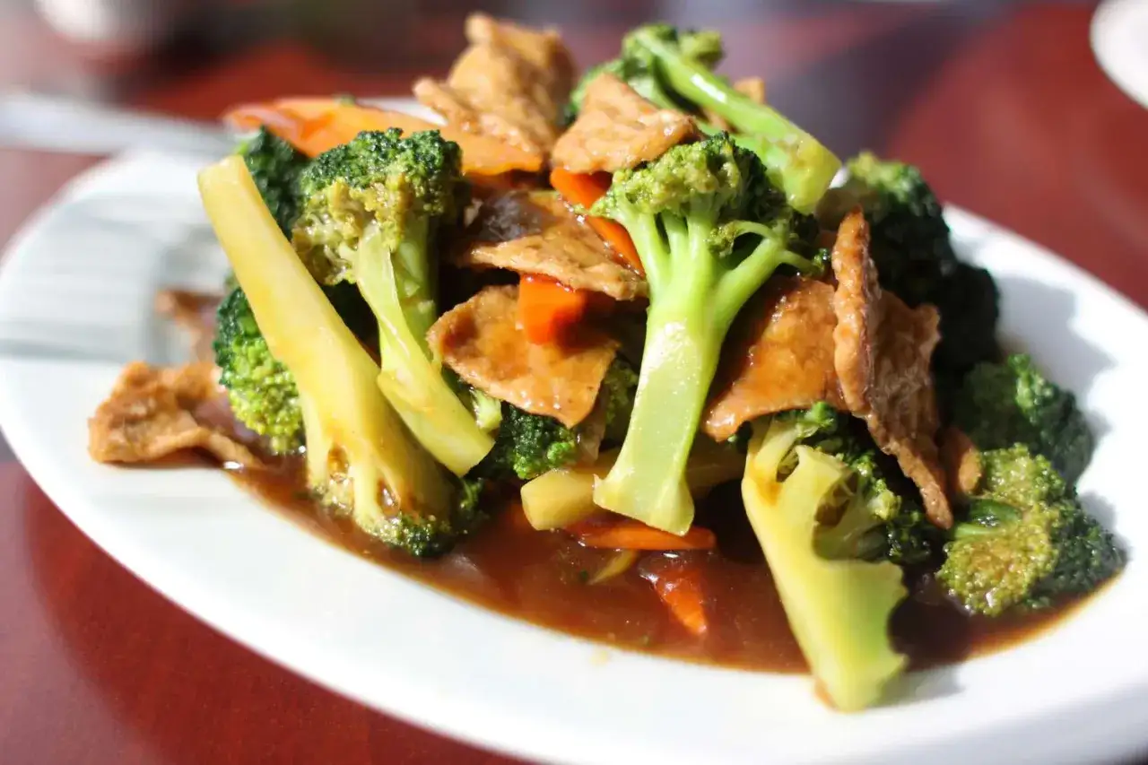 Plato de brócoli y zanahoria salteados con trozos de seitan en salsa. ¡Una deliciosa forma de aprender como hacer seitan!