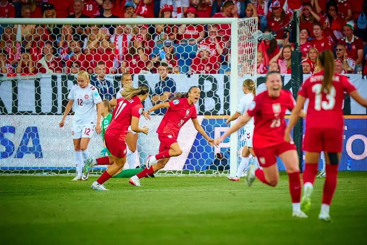 Piłkarki w czerwonych strojach świętują bramkę. Jedna z nich, z numerem 13, cieszy się z gola. To piękne polskie dania na boisku!