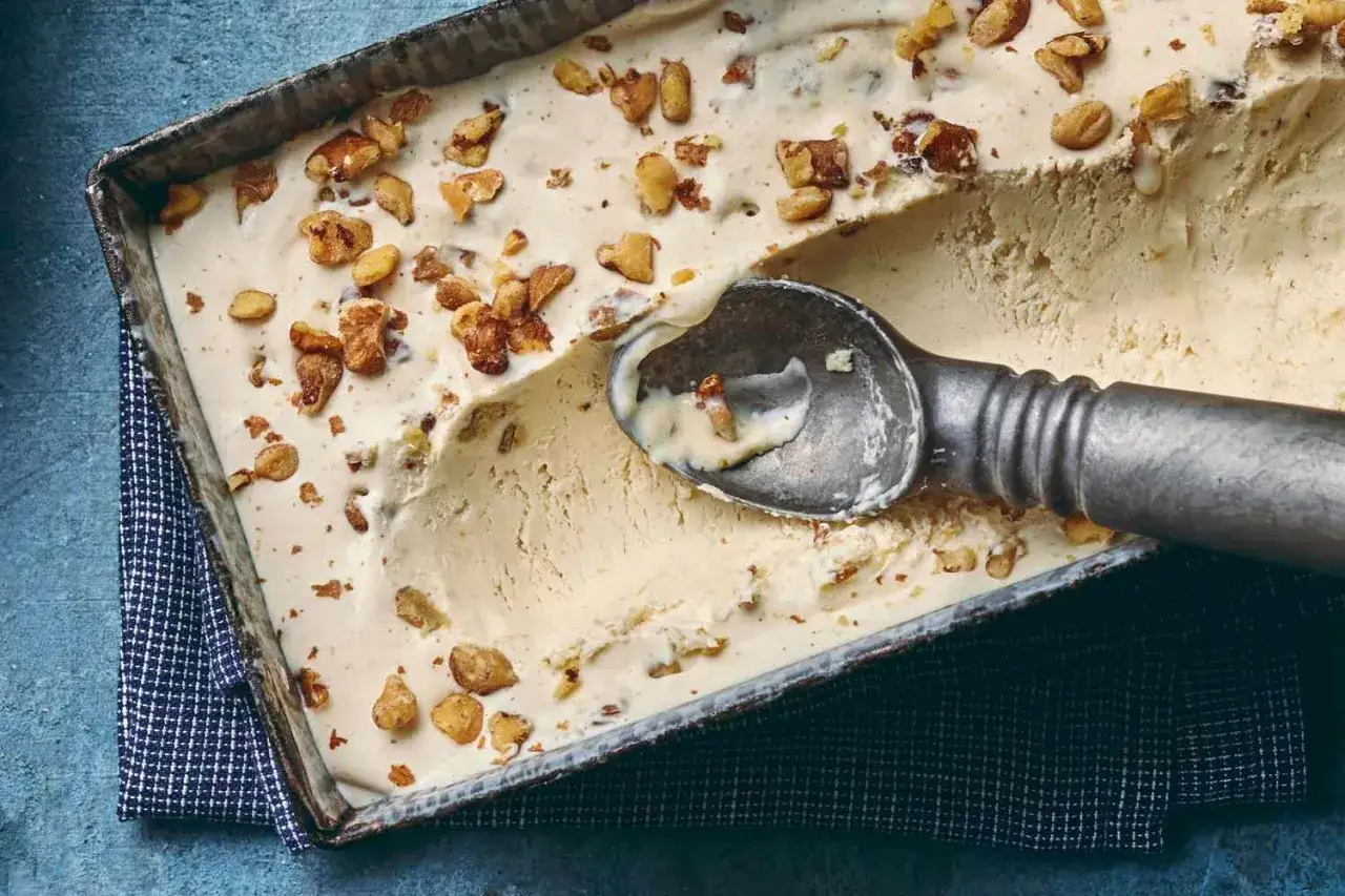 Cremiges Eis mit Walnussstückchen, das an die Wirkung von schwarzer Walnuss erinnert. Ein Löffel ist bereits eingetaucht.