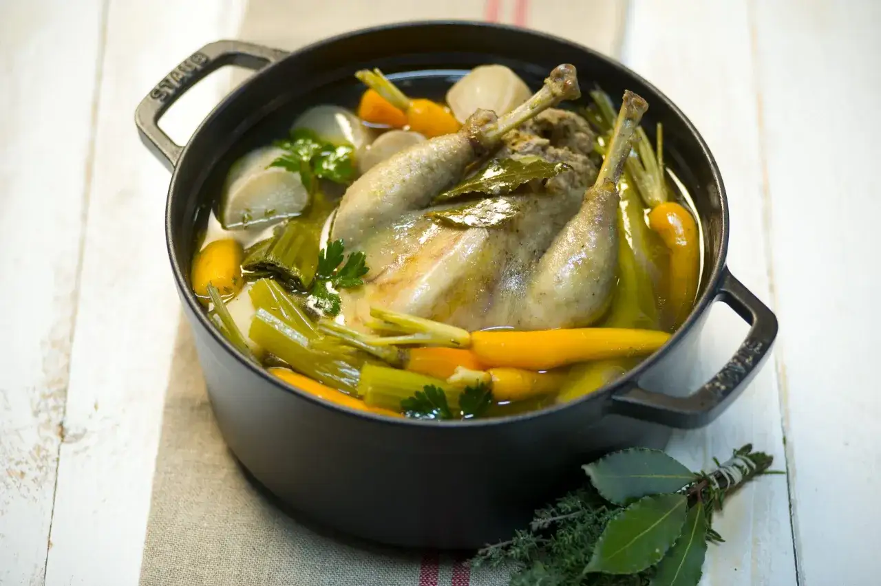 Un plat mijoté de poule au pot, avec carottes, poireaux et navets dans un bouillon parfumé. Un délice réconfortant.
