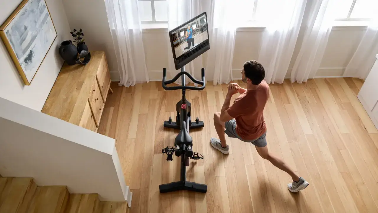 Mann macht jeden Tag 20 Minuten Hometrainer. Er trainiert vor einem Bildschirm, der eine Fitness-&Uuml;bung zeigt.