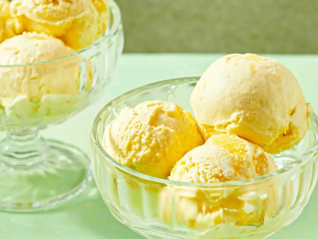 Schüssel mit cremigem, gelbem Eis, das an einem sonnigen Tag erfrischt.