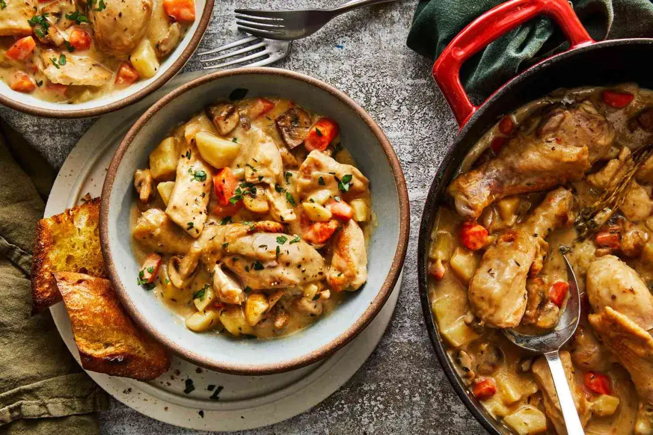 A comforting bowl of Japanese cream stew, featuring tender chicken, potatoes, carrots, and mushrooms in a rich, creamy sauce, served with toasted bread.