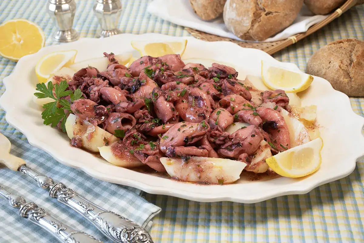 Chipirones a la plancha, tiernos y jugosos, servidos con patatas y gajos de limón. Un plato delicioso.