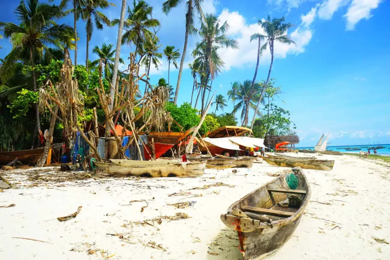 Plaża na Zanzibarze z łodziami i palmami. Zastanawiasz się, ile pieniędzy zabrać na Zanzibar?