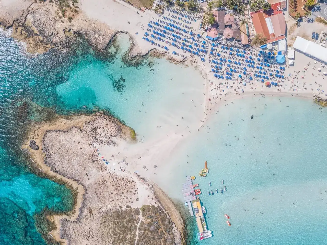 Piękna plaża na Cyprze, turkusowa woda, leżaki i parasole. Sprawdź aktualne cypr ceny i zaplanuj wakacje!