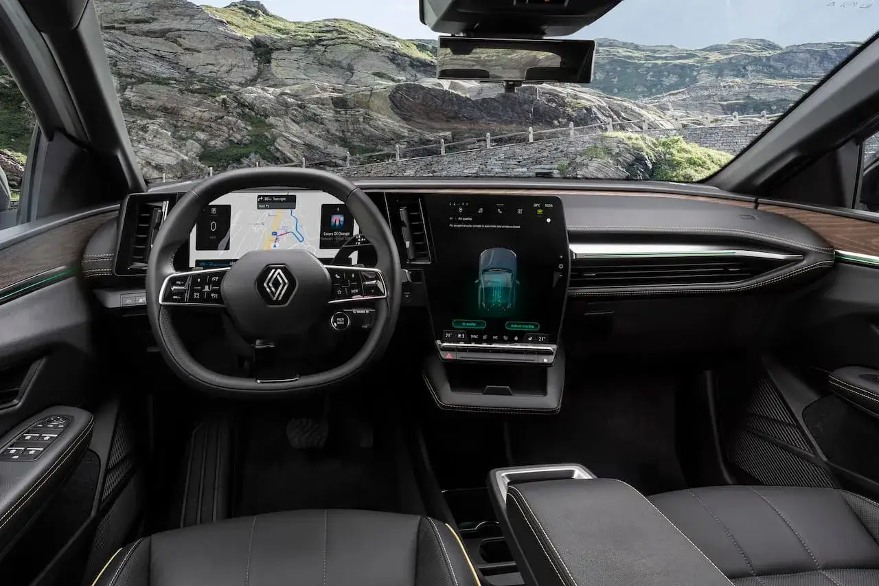 Interiörbild från en Renault Megane E-Tech testkörning. Digital instrumentpanel med navigation och stor pekskärm.
