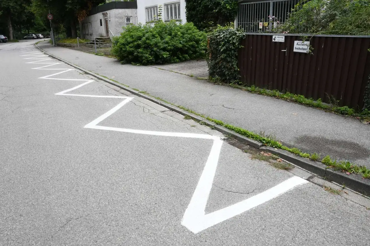 Zickzack-Markierungen auf der Stra&szlig;e zeigen an, wo das Parken erlaubt ist, mit einem abgesenkten Bordstein f&uuml;r leichten Zugang.