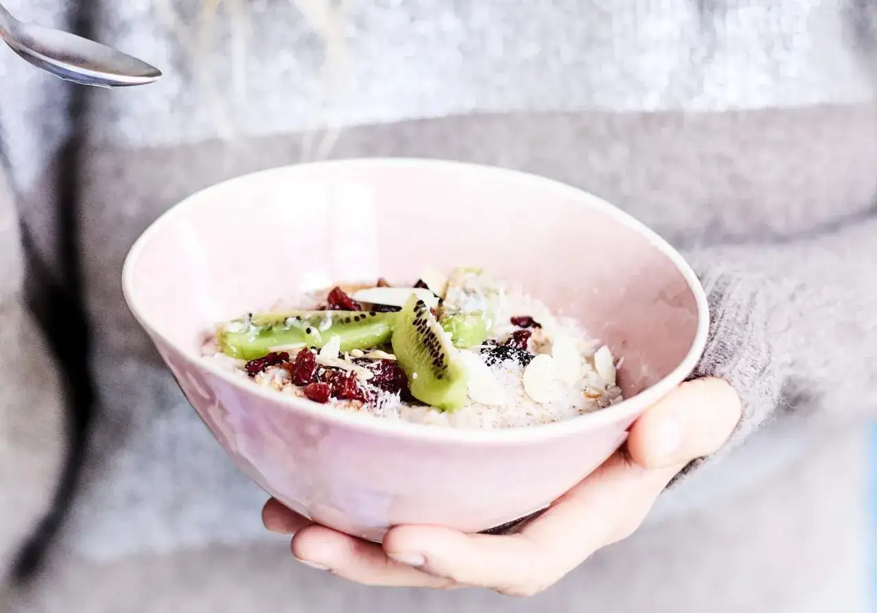 Bol rose rempli de flocons d'avoine, de kiwi, de cranberries et d'amandes effil&eacute;es. Parfait pour un r&eacute;gime sans gluten, quoi manger pour un petit-d&eacute;jeuner sain.