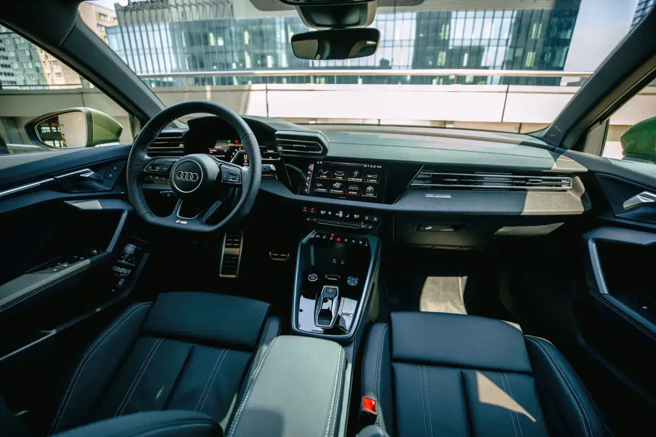 Wnętrze nowego Audi A3: skórzane fotele, cyfrowe zegary i nowoczesny ekran multimedialny.