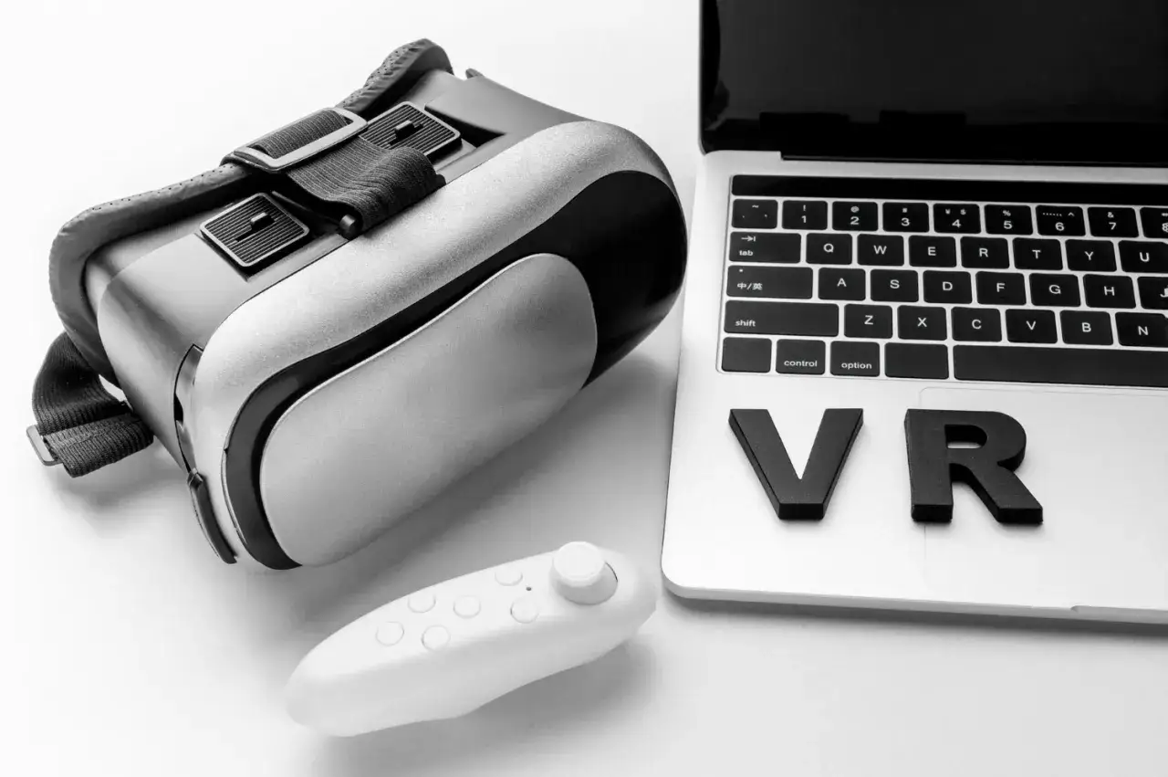 Casque de r&eacute;alit&eacute; virtuelle, manette et ordinateur portable avec les lettres 