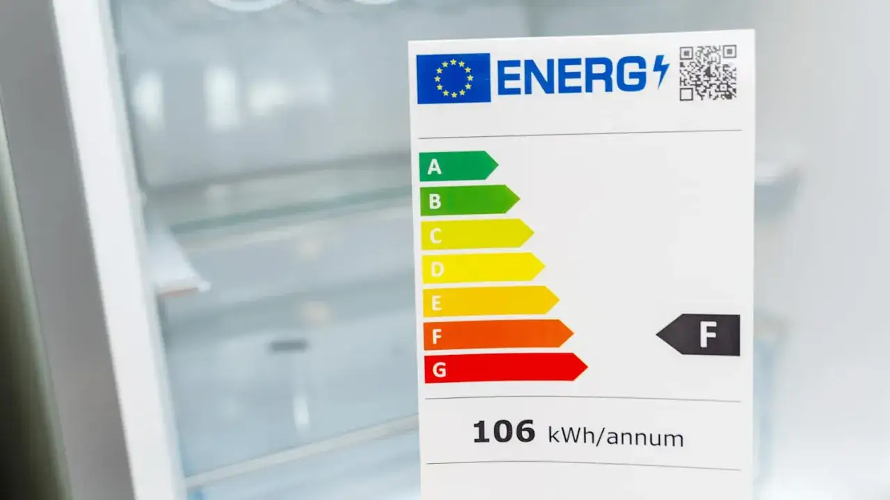 Neues Energielabel an einem Kühlschrank zeigt Klasse F und 106 kWh/annum.