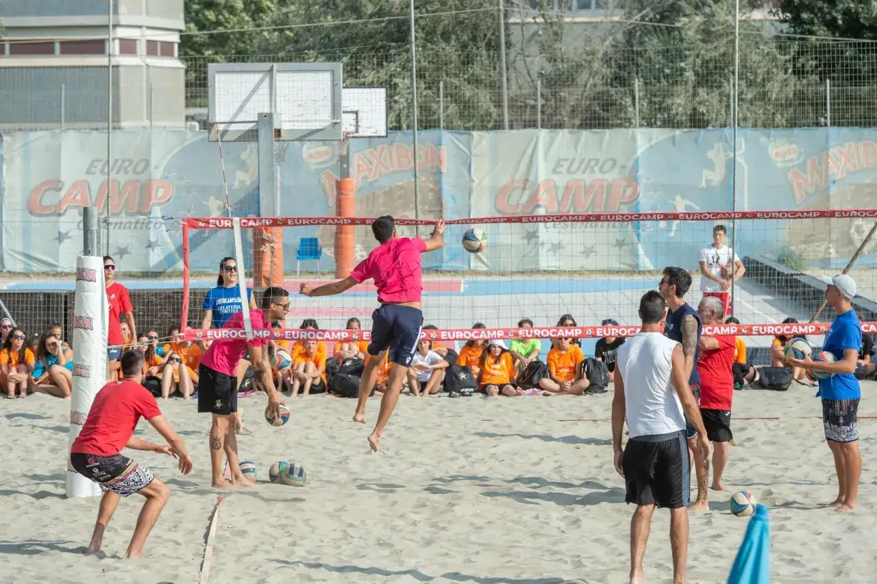 Partita di camp volley Cesenatico. Giocatori in azione sulla sabbia, pubblico sugli spalti.