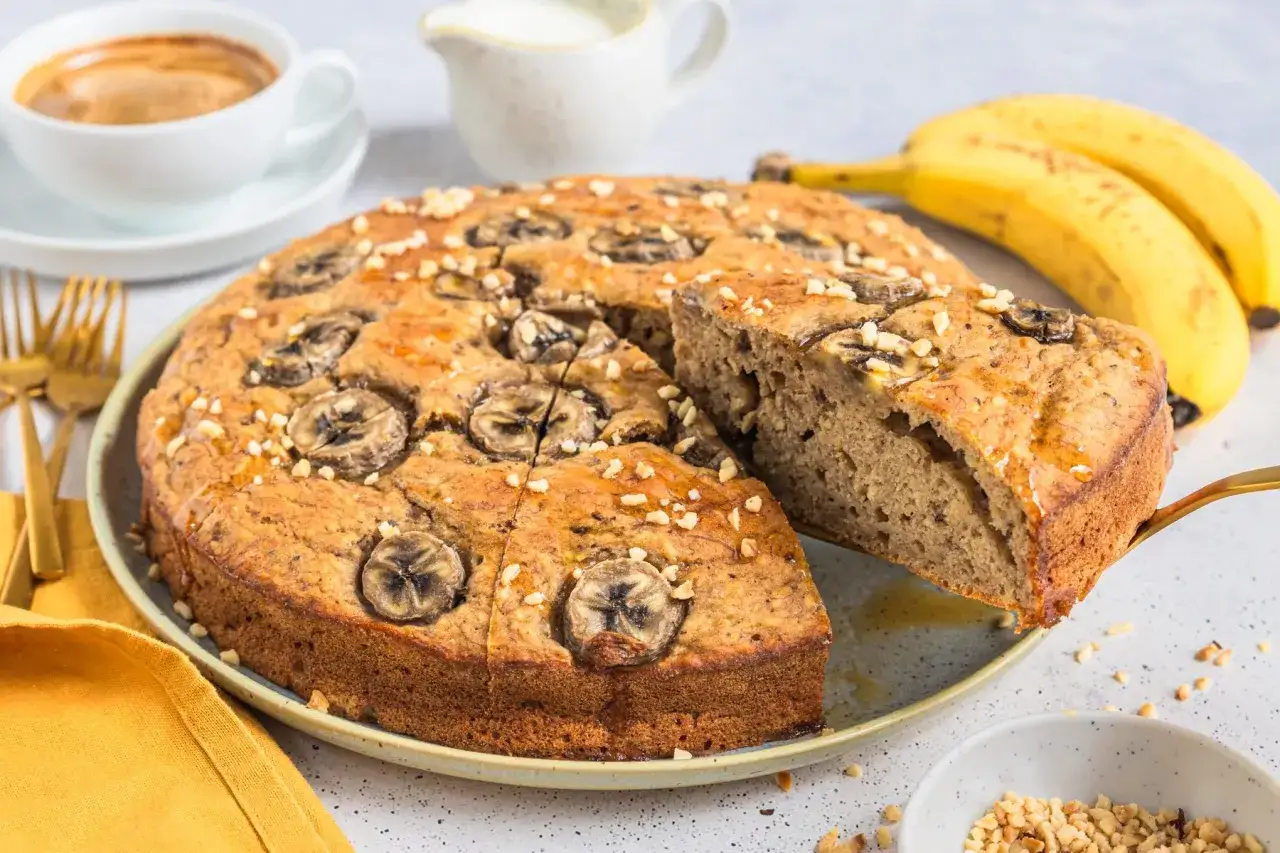 Saftiger Bananenkuchen ohne Zucker, garniert mit Bananenscheiben und N&uuml;ssen. Perfekt zum Kaffee.