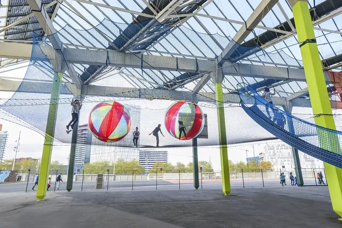 Niños jugando en una red gigante con pelotas inflables. ¡Un lugar ideal para celebrar tu cumpleaños de 11 años!
