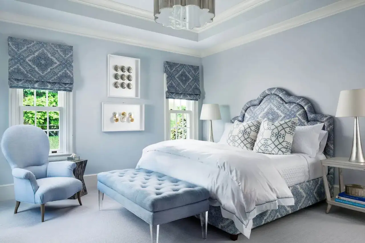 Ein stilvolles **Schlafzimmer blau grau** mit einem auffälligen Bettkopfteil, einem Sessel und einem Hocker.