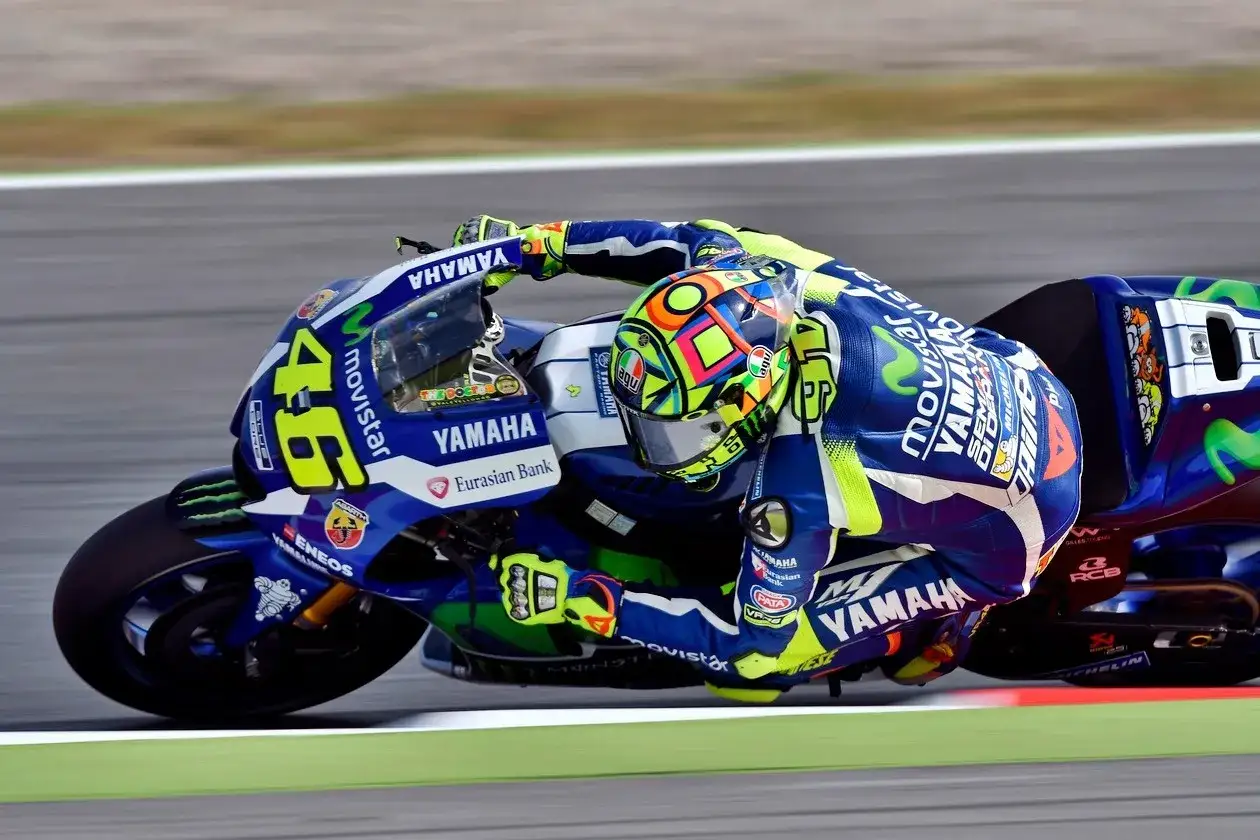 Valentino Rossi inclinado en su moto Yamaha azul y amarilla, n&uacute;mero 46, en plena carrera.