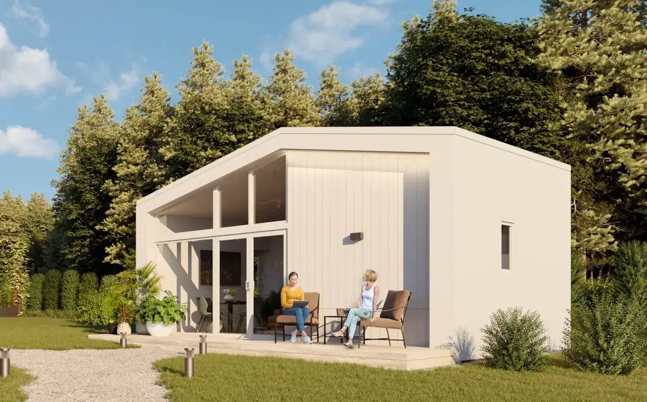 Två kvinnor sitter på en altan framför ett modernt, ljust hus. En dröm om att bygga hus billigt blir verklighet med denna stilrena design.