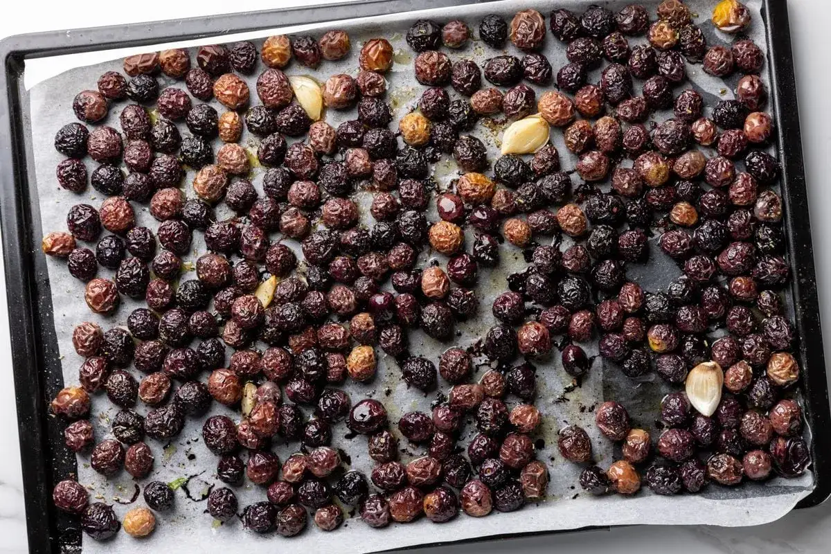 Olive nere al forno alla pugliese, condite con aglio e erbe aromatiche, pronte per essere gustate.