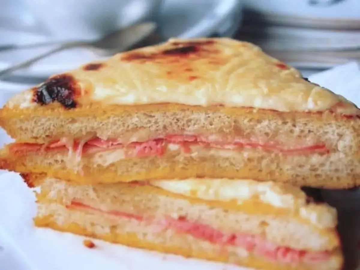 Zwei H&auml;lften eines k&ouml;stlichen Croque Monsieur mit geschmolzenem K&auml;se und Schinken.