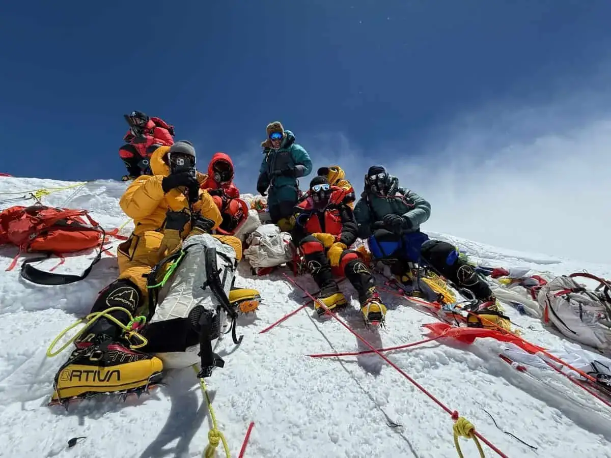 Grupa alpinist&oacute;w w sprzęcie tlenowym odpoczywa na śniegu, przygotowując się do zdobywania ośmiotysięcznik&oacute;w.