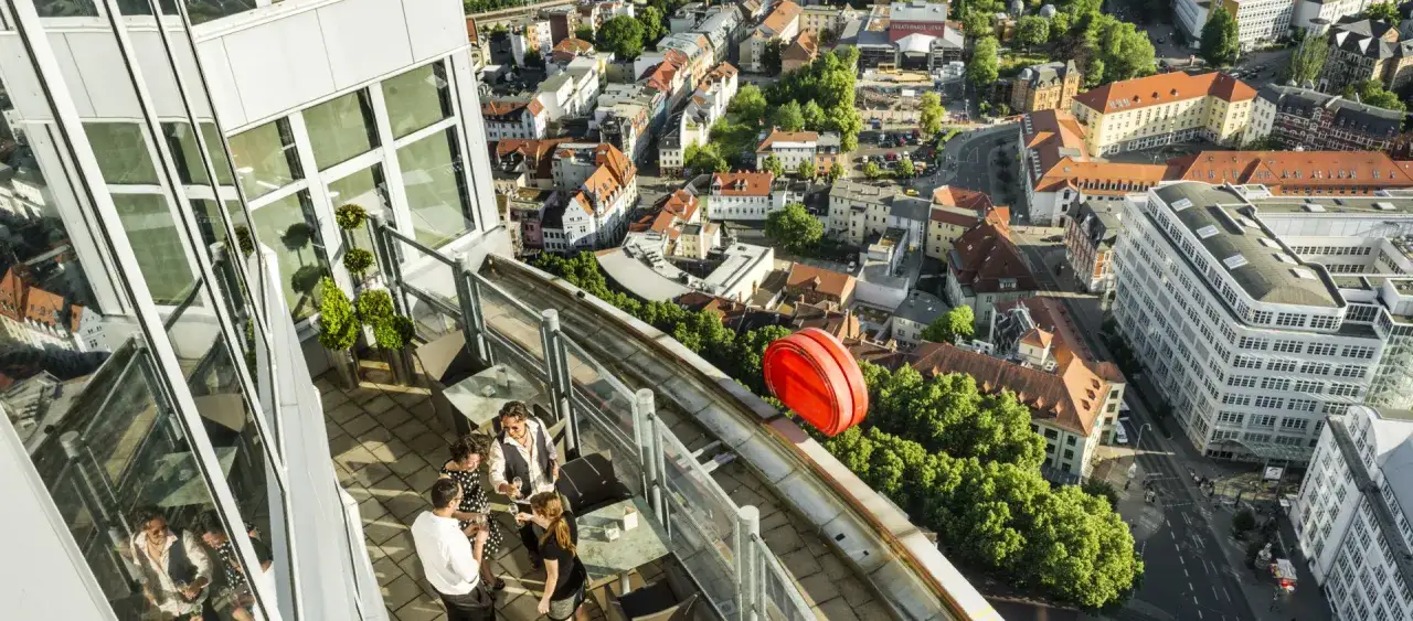 Genießen Sie den Ausblick über Jena von einer Dachterrasse. Hier kann man entspannt mit Freunden anstoßen und das Stadtleben erkunden.