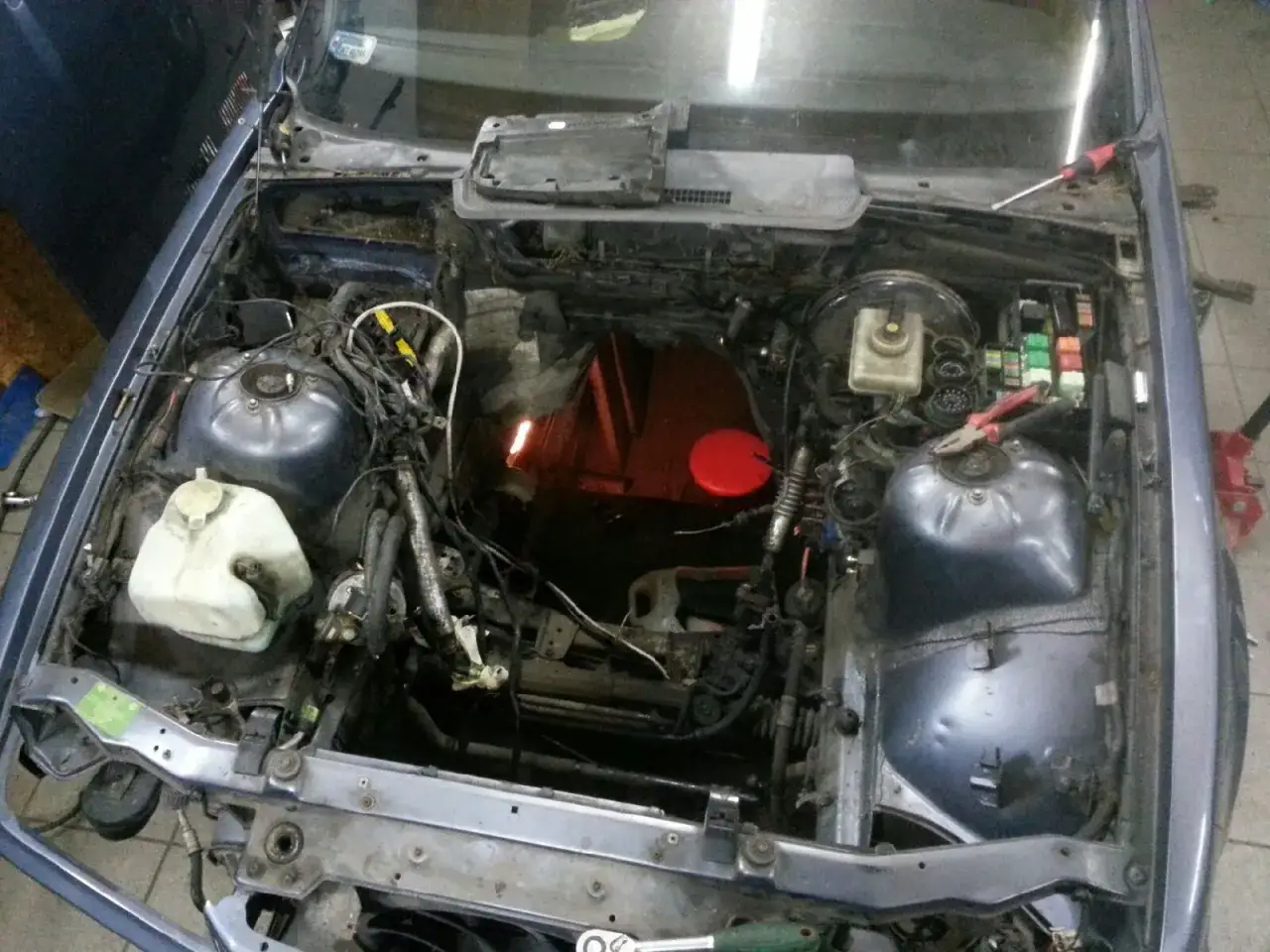 Silnik m52b20 w trakcie prac. Widoczne elementy układu chłodzenia, elektryki i skrzynki bezpieczników.