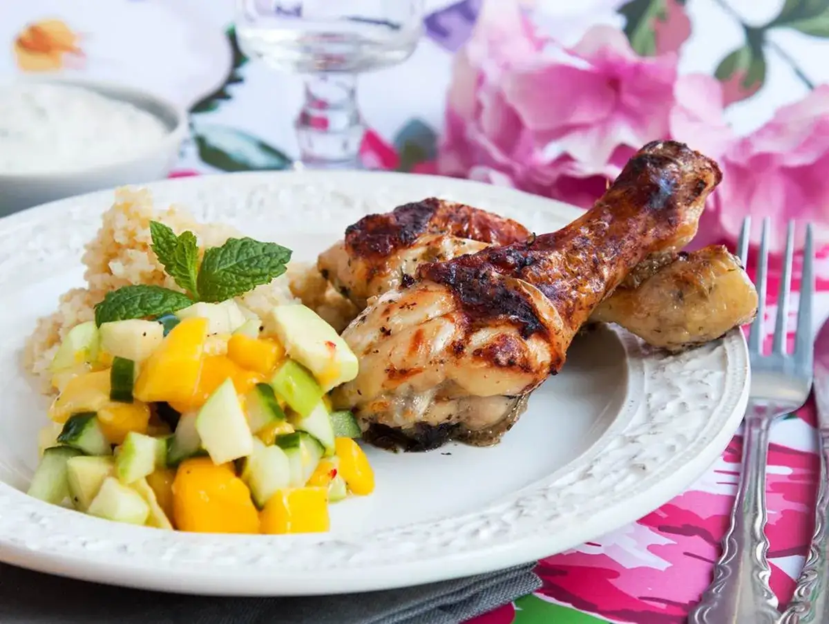 Grillade kycklingben med couscous och en fr&auml;sch mangosallad. Perfekt temperatur f&ouml;r saftiga kycklingben.