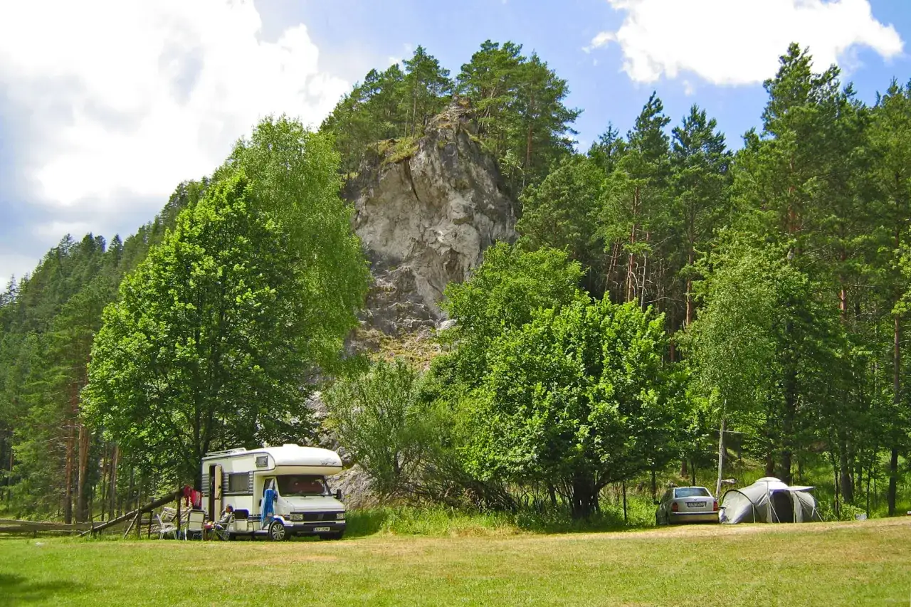 Wohnmobil und Zelt campen vor Felsen und Wald. Tolle slowakei reisetipps für Naturliebhaber.