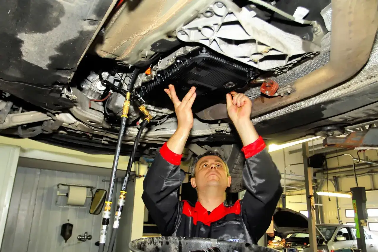 mechanik wymienia olej w automatycznej skrzyni biegów
