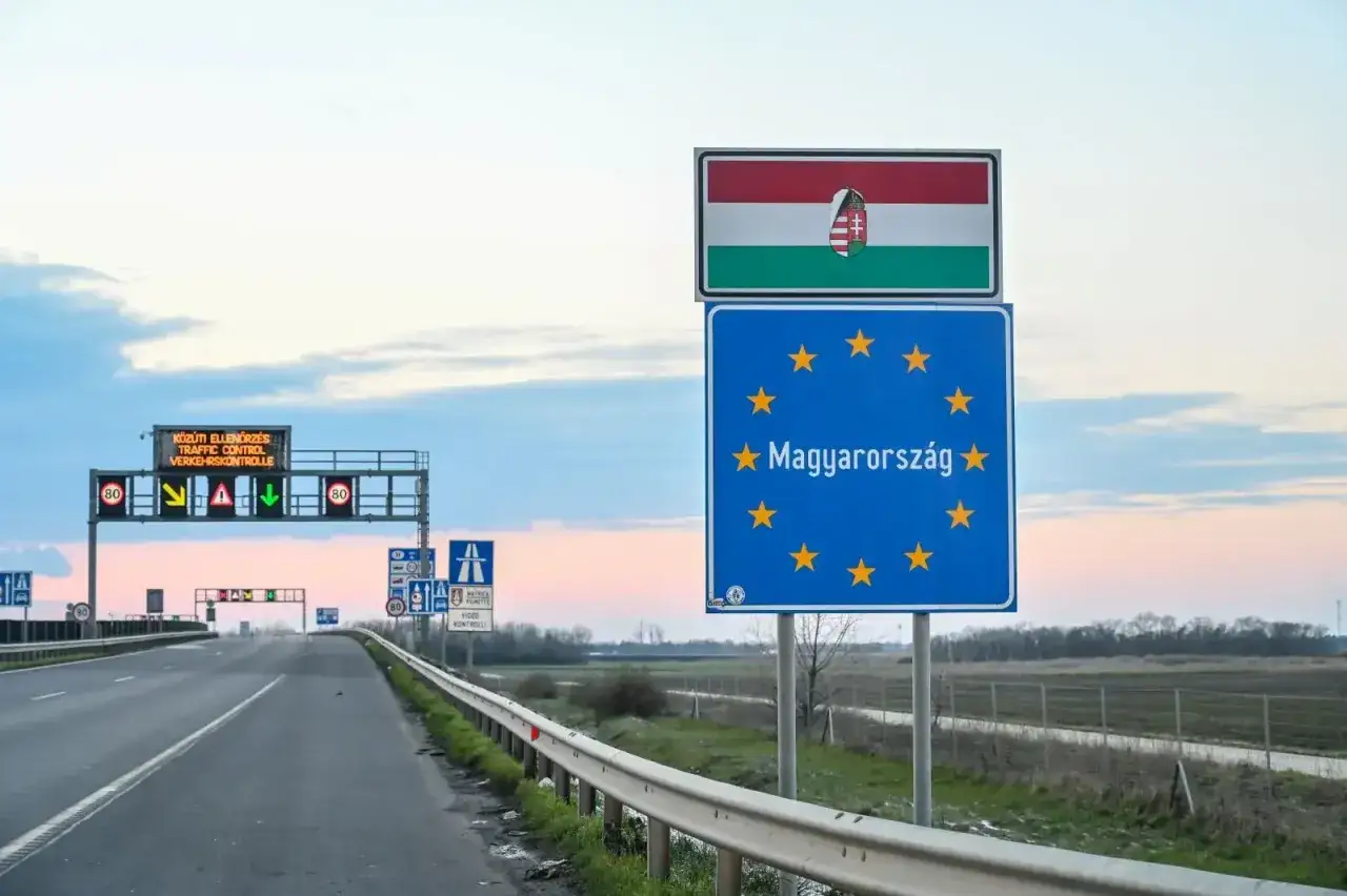 Granica Węgier. Znak UE i flaga Węgier. Na drodze znaki informujące o kontroli ruchu, możliwe, że także o kontroli wagi, co może skutkować mandatem za wagę Węgry.