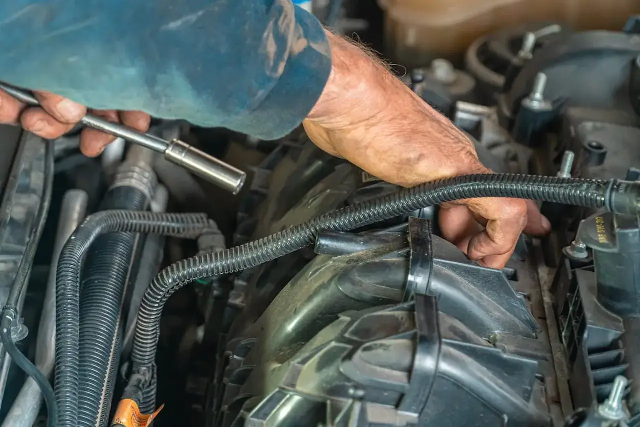 Mechanik sprawdza uszkodzoną gruszkę paliwa, szukając objawów awarii silnika.