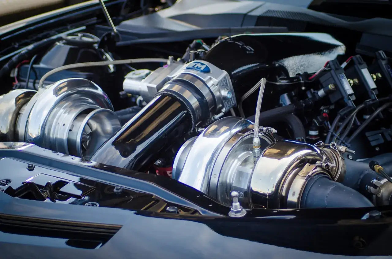Motore turbo diesel con due turbocompressori cromati lucidi e tubi neri.
