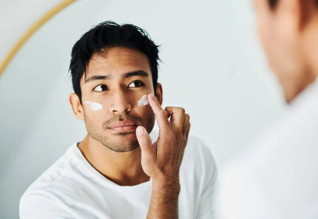 Un homme applique de la cr&egrave;me sur son visage, une &eacute;tape essentielle pour savoir a quoi sert la creme solaire : prot&eacute;ger sa peau.