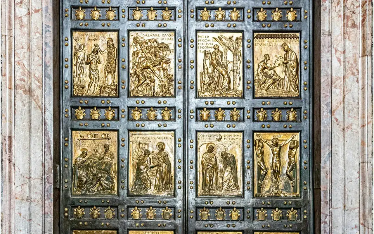 Die bronzene heilige Pforte des Petersdoms zeigt in Reliefs biblische Szenen, darunter die Taufe Jesu und die Kreuzigung.