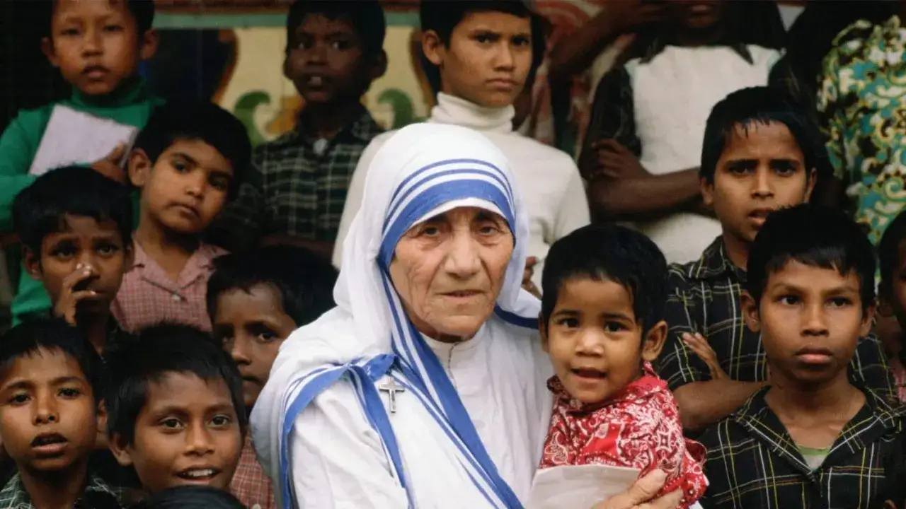 Mother Teresa, the missionaries of charity founder, holds a child surrounded by many young faces.