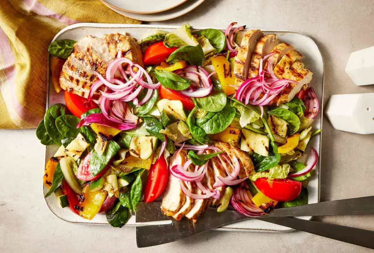 Grillad kycklingsallad med grönsaker och rödlök, en hälsosam måltid som påminner om rikshospitalets diet.