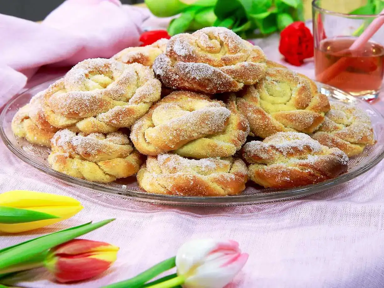 En tallrik med gyllene vaniljbullar, strösslade med socker. Perfekt för ett mysigt fika, kanske med detta vaniljbullar recept.