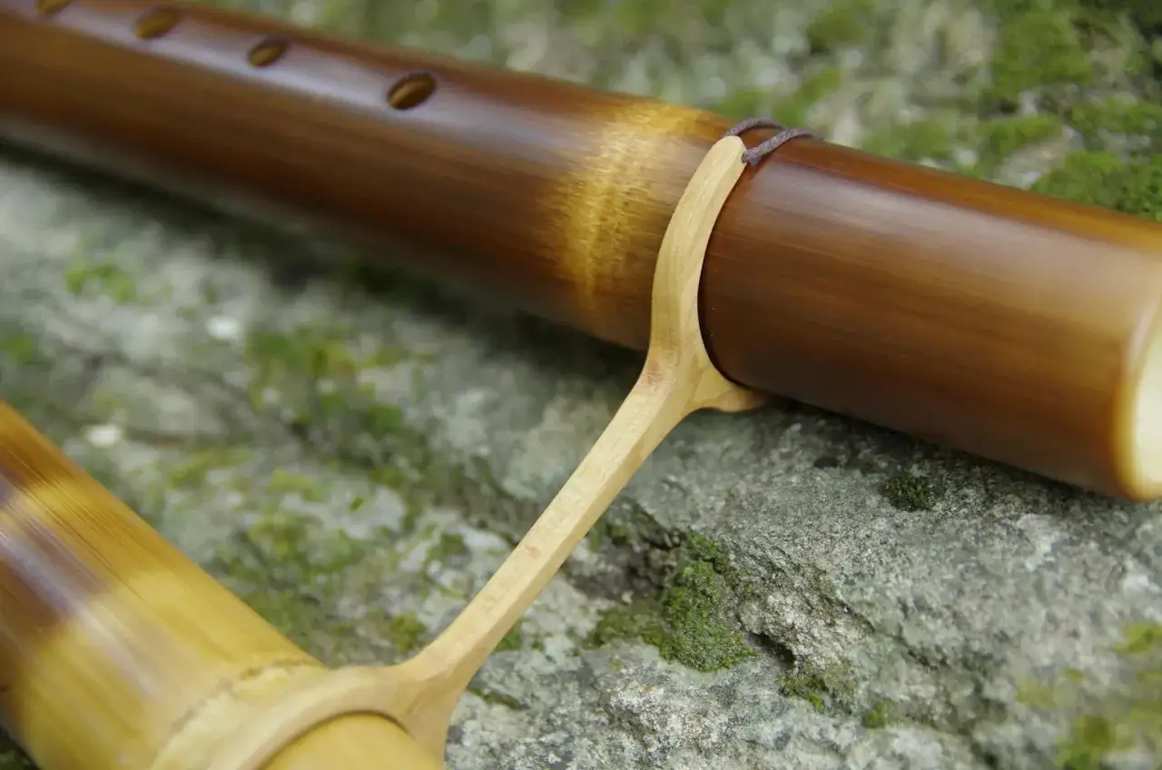 D&eacute;tail d'une fl&ucirc;te en bambou, en cours de fabrication, pos&eacute;e sur des pierres moussues. L'artisanat pour fabriquer flute bambou.