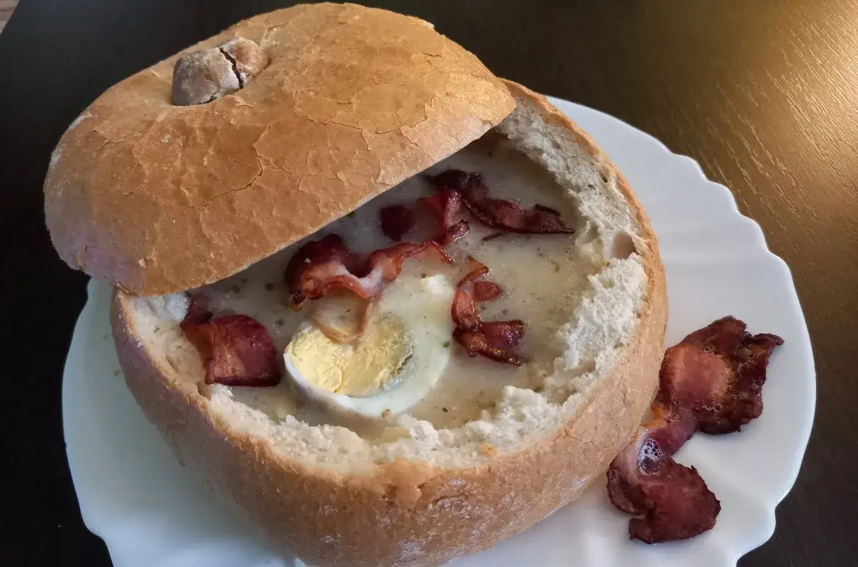 Pyszny żurek na zakwasie z butelki, podany w chlebie z jajkiem i chrupiącym boczkiem.