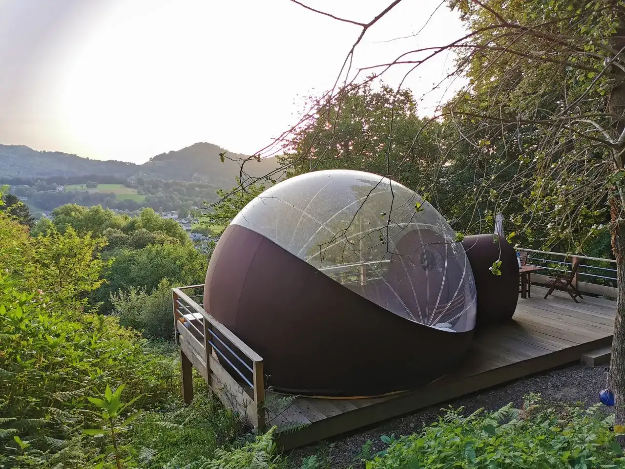 Une bulle transparente sur une terrasse en bois, offrant une vue sur les collines verdoyantes. L'endroit idéal pour dormir dans une bulle en Occitanie.