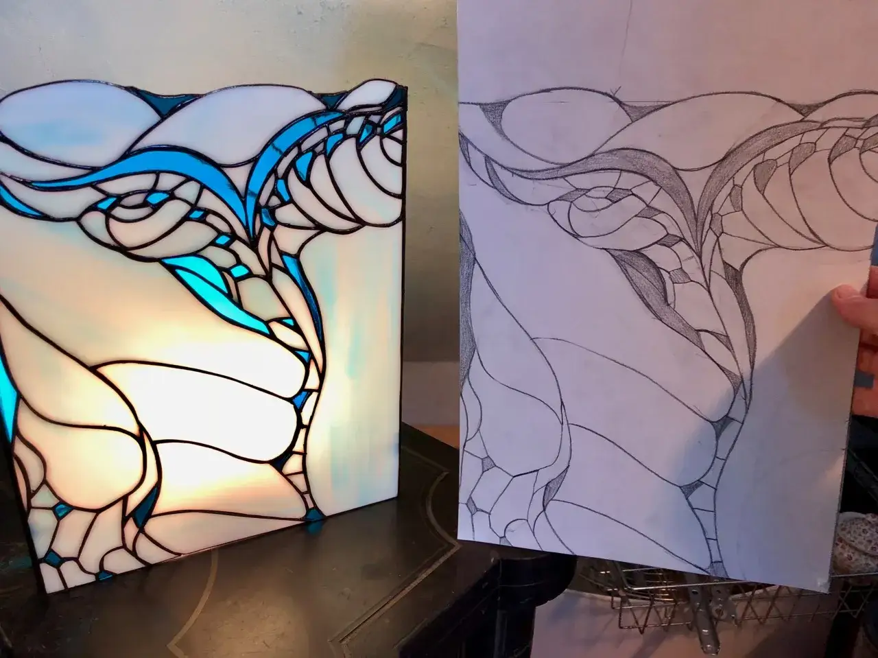 Le vitrail wecandoo, aux formes organiques bleues et blanches, est pr&eacute;sent&eacute; &agrave; c&ocirc;t&eacute; de son croquis pr&eacute;paratoire.