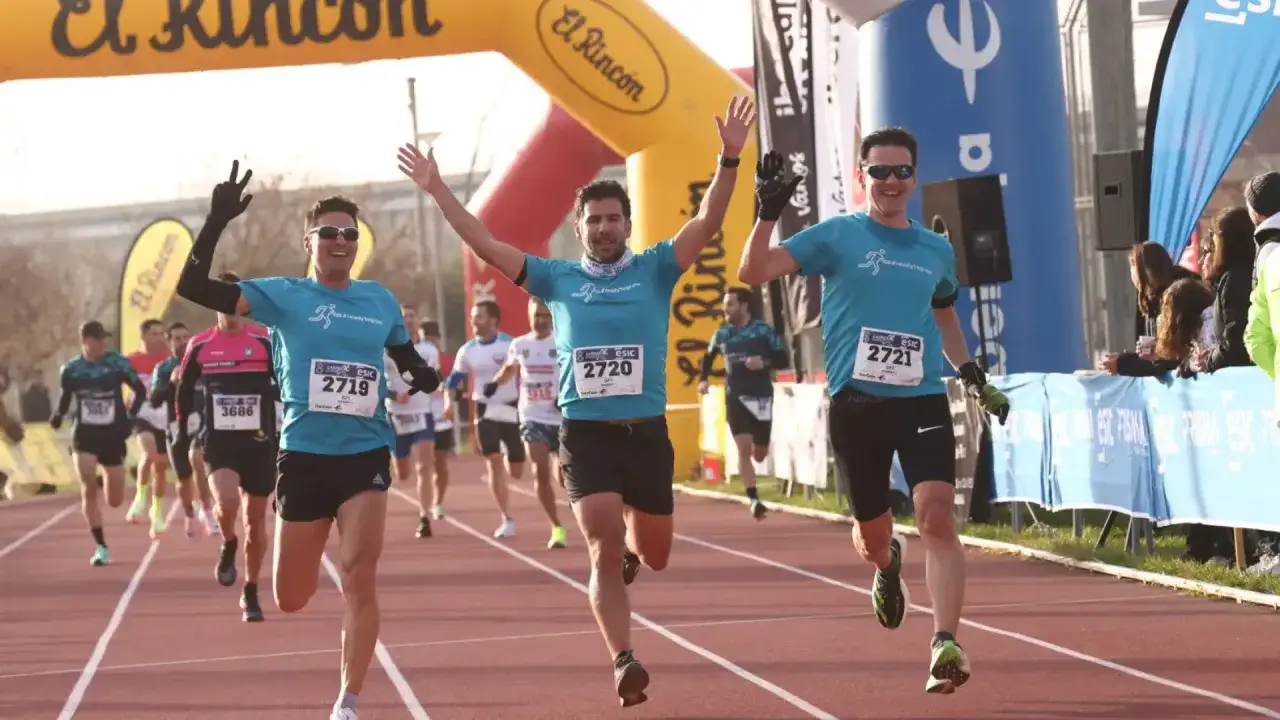 Atletas cruzan la meta en una carrera de empresas en Zaragoza. El corredor 2719 celebra su victoria.