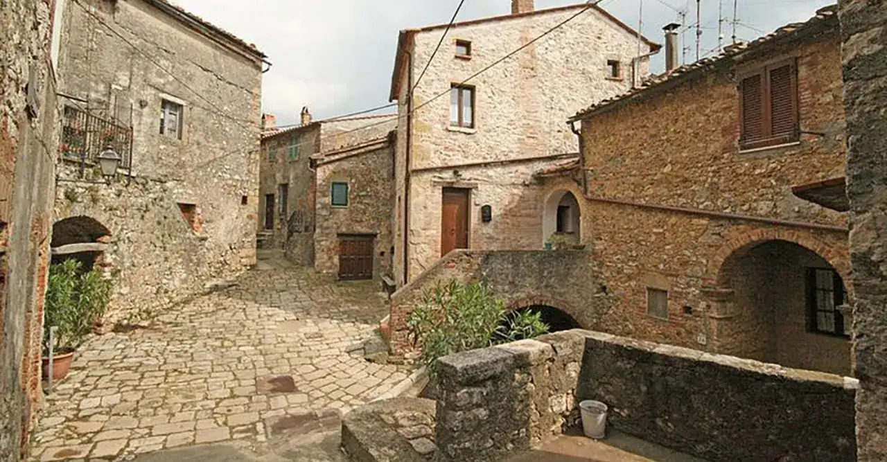 Un vicolo acciottolato a Semproniano, con case in pietra e archi. Un luogo incantevole da esplorare, pieno di storia e fascino.