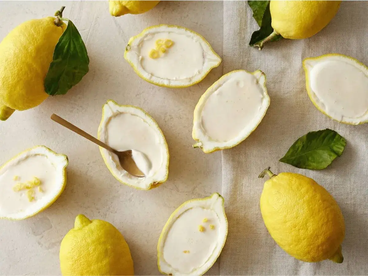 Citroner fyllda med krämig dessert, som en härlig kärleksmums påsk. En gyllene sked vilar i en citronhalva.