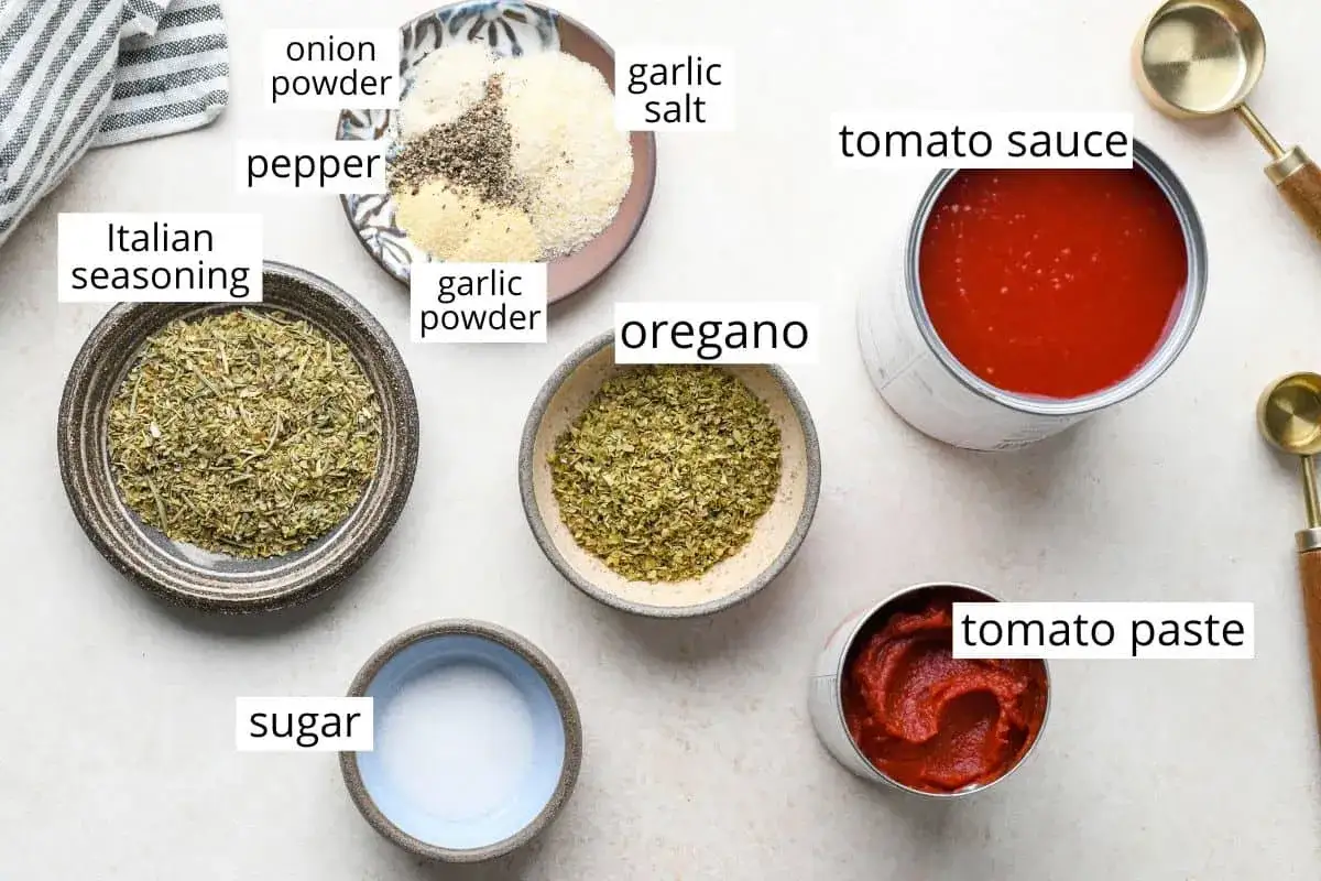 Składniki na domowy sos do pizzy: puszka pomidorów, koncentrat pomidorowy, oregano, włoskie zioła, czosnek, cebula, pieprz, sól i cukier.