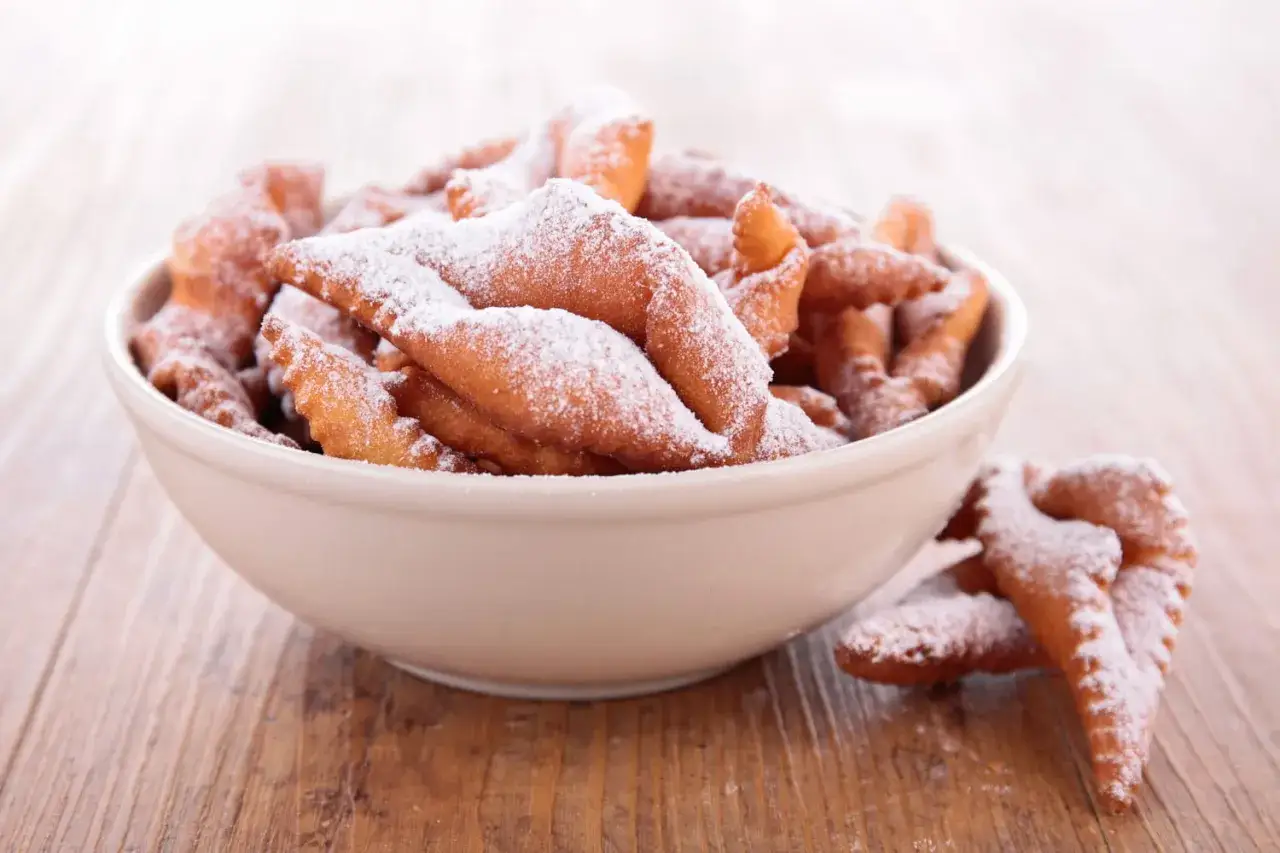 Délicieux beignets de carnaval saupoudrés de sucre glace, inspirés par la recette de Cyril Lignac. Parfaits pour la fête !
