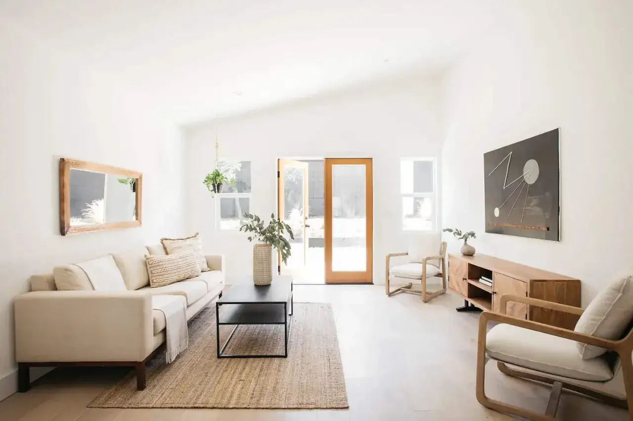 Helles Wohnzimmer mit beigem Sofa, Holzakzenten und Pflanzen. Ein Beispiel f&uuml;r **minimalismus im alltag**.